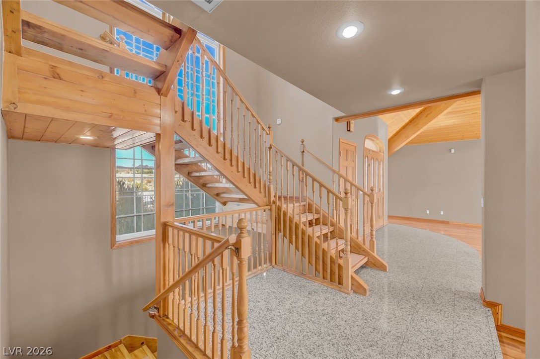 640 North Racetrack Road Henderson, NV 89015 - Photo 29 of 65 Natural wood staircase with intricate banister details ascends gracefully from a polished floor.