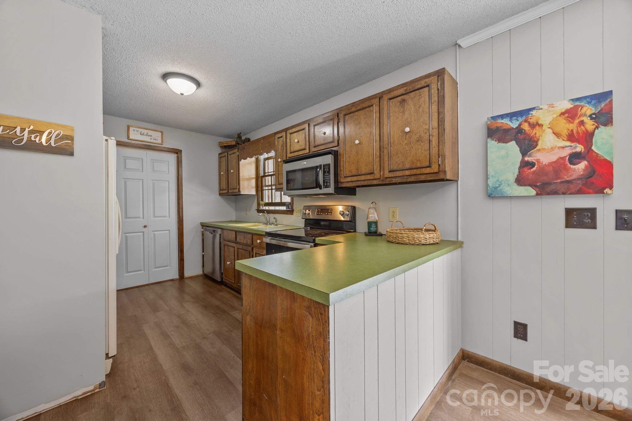 9698 Pine Tree Road, Unit 55 Norwood, NC 28128 - Photo 11 of 29 a kitchen with stainless steel appliances granite countertop a sink stove and refrigerator