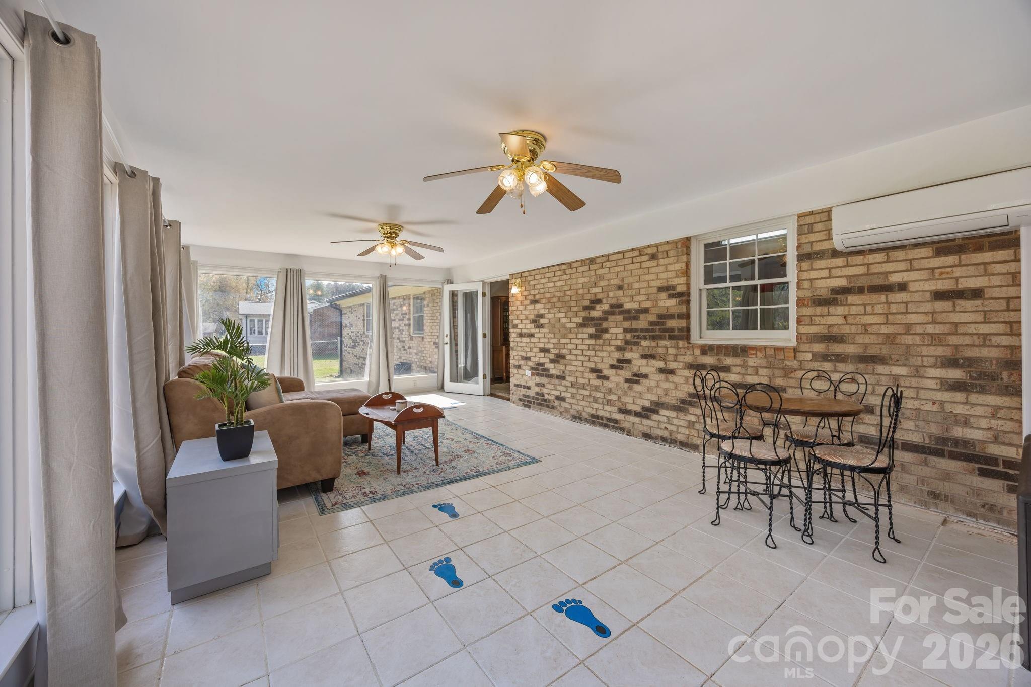 9698 Pine Tree Road, Unit 55 Norwood, NC 28128 - Photo 15 of 29 a living room with patio furniture and a chandelier