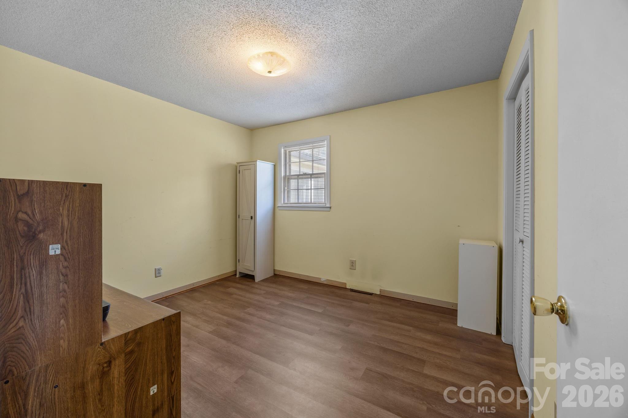 9698 Pine Tree Road, Unit 55 Norwood, NC 28128 - Photo 17 of 29 an empty room with wooden floor and windows