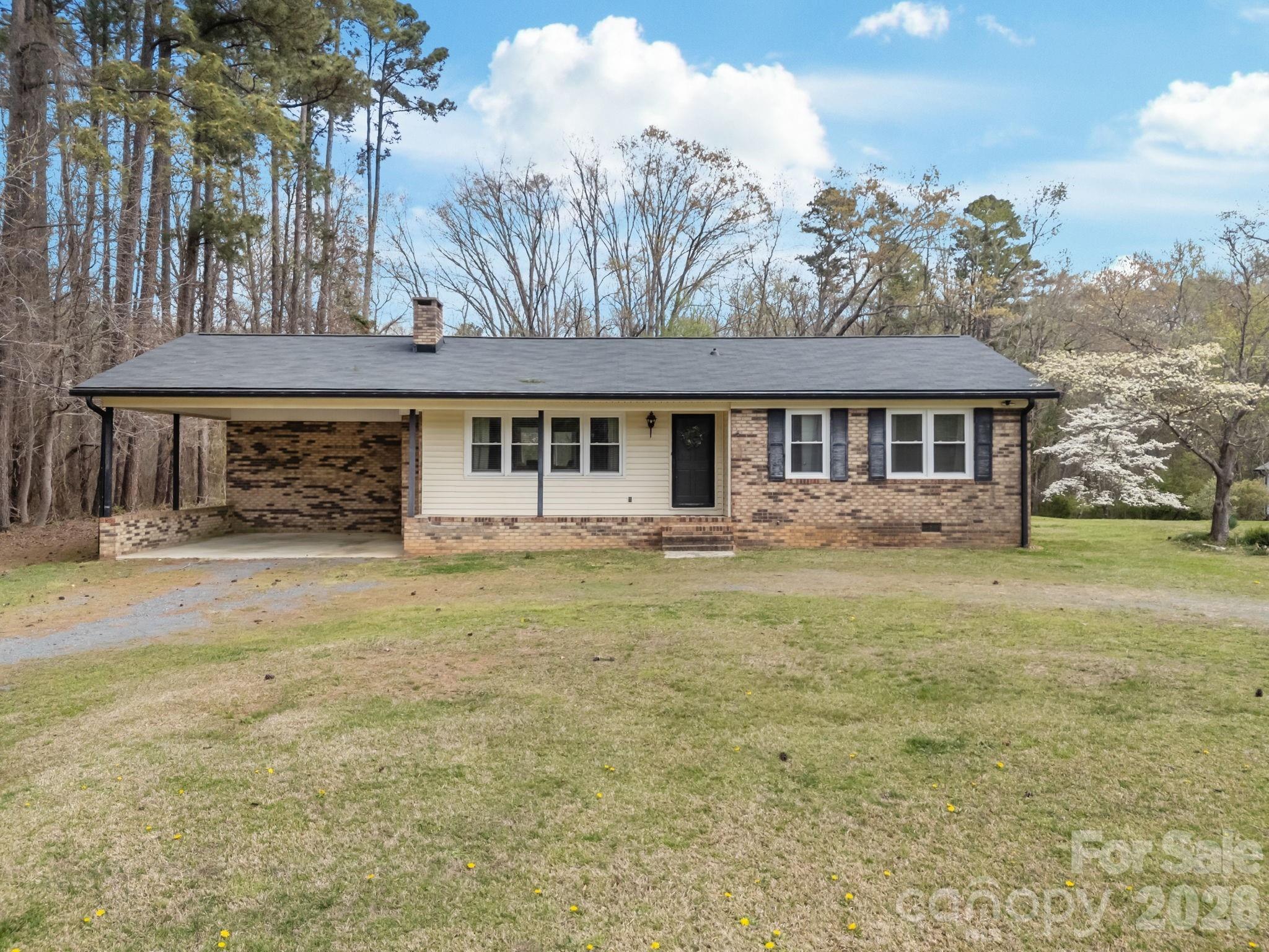 9698 Pine Tree Road, Unit 55 Norwood, NC 28128 - Photo 2 of 29 a front view of a house with a garden