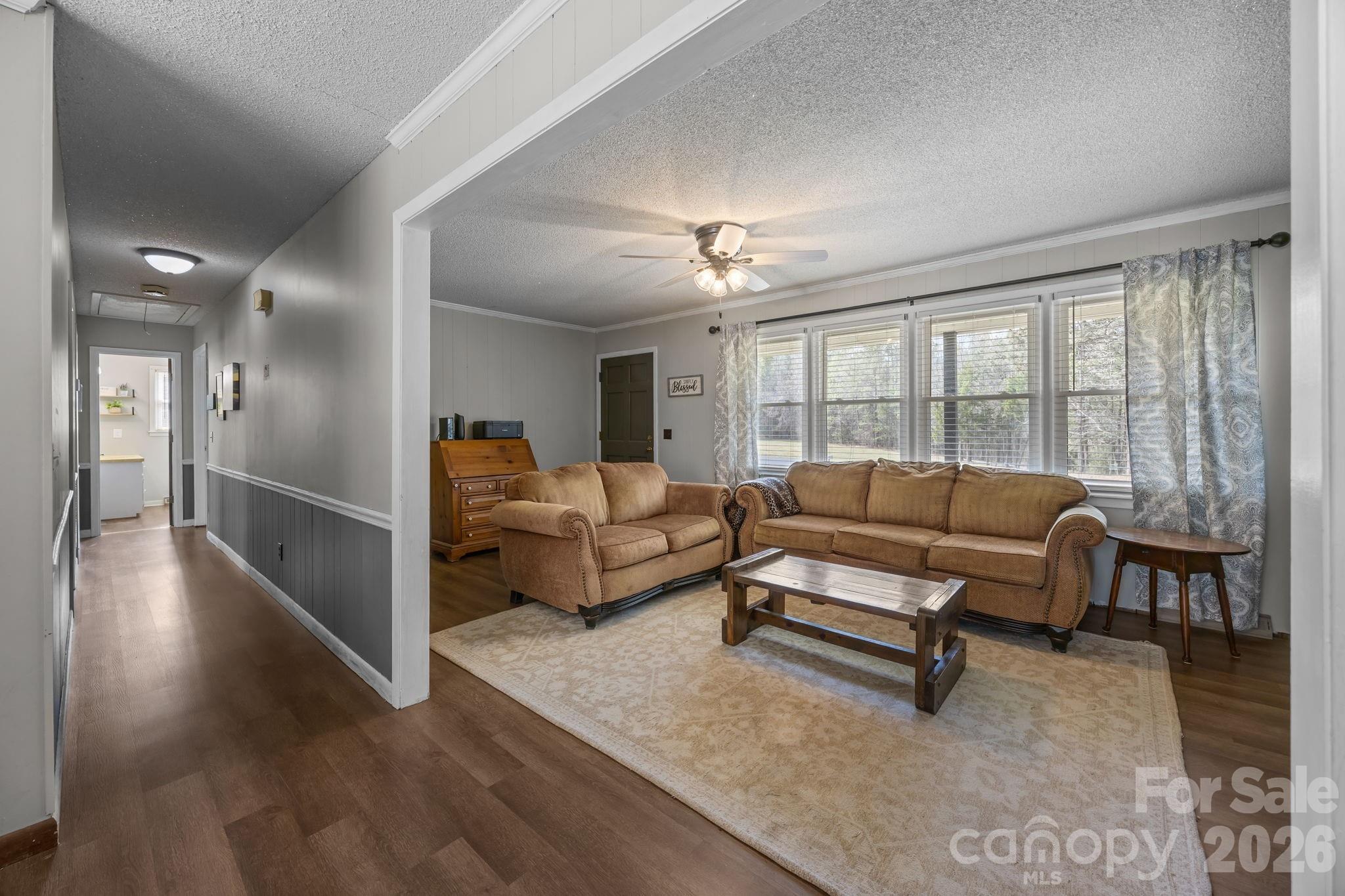 9698 Pine Tree Road, Unit 55 Norwood, NC 28128 - Photo 9 of 29 a living room with furniture and a chandelier