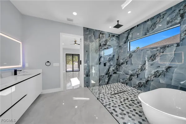 a bathroom with a bathtub sink and mirror
