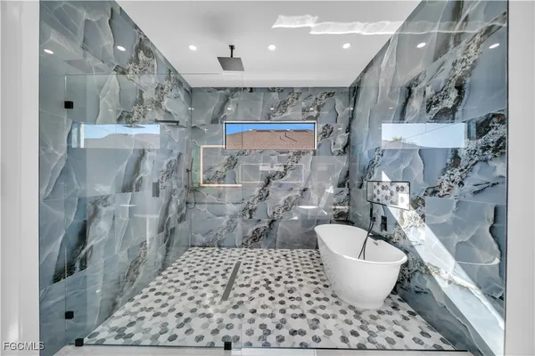 a large white room with a bathtub and a shower