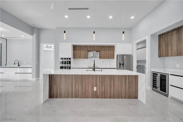 a large kitchen with stainless steel appliances a large counter top a stove and a refrigerator