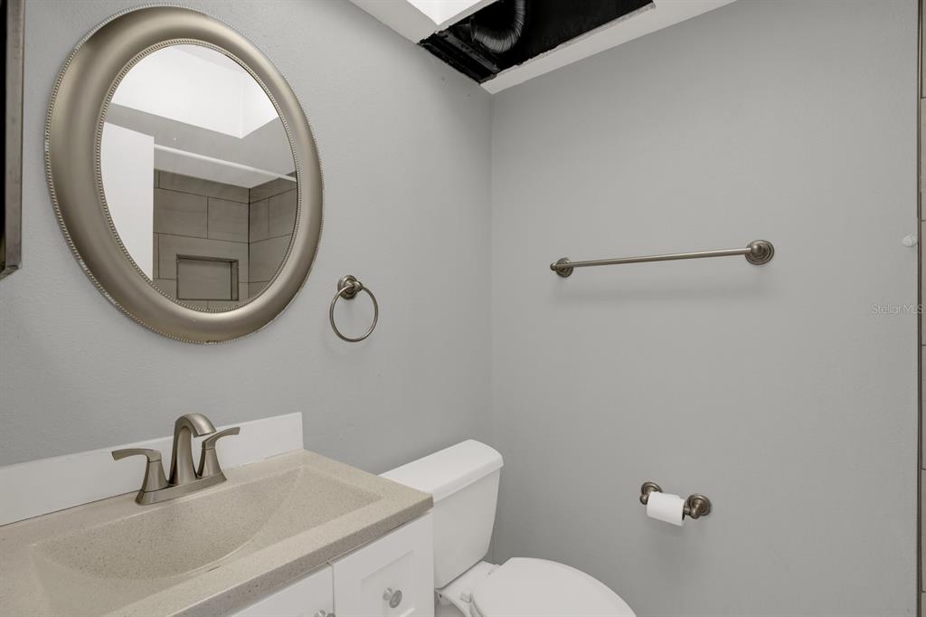 4939 Floramar Terrace, Unit 204 New Port Richey, FL 34652 - Photo 15 of 22 a bathroom with a toilet sink and mirror
