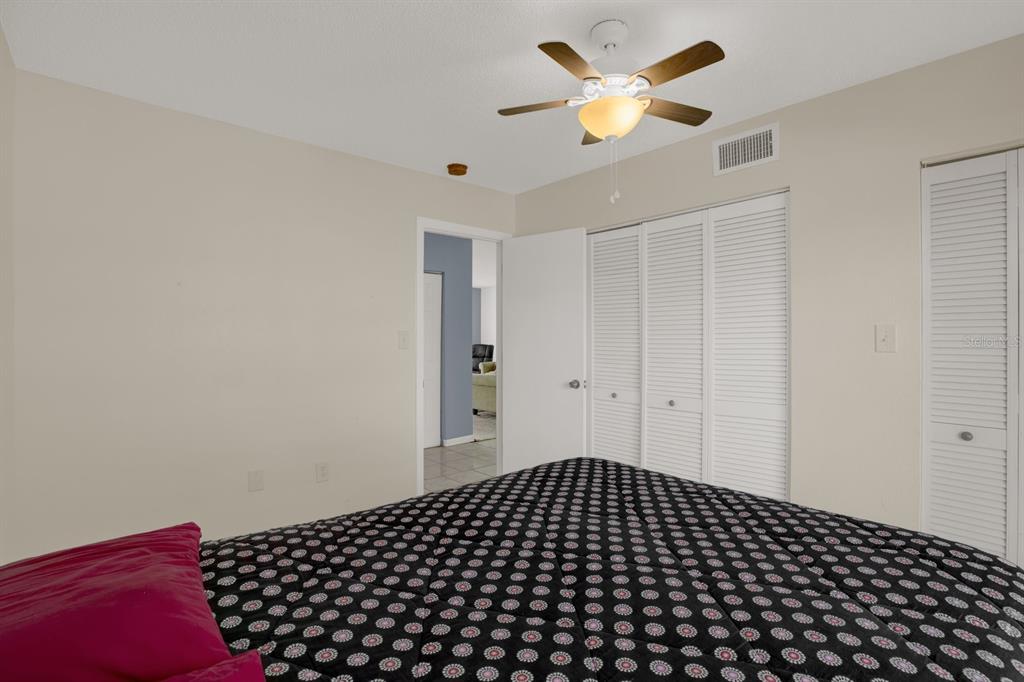 4939 Floramar Terrace, Unit 204 New Port Richey, FL 34652 - Photo 17 of 22 a view of a bedroom with a ceiling fan