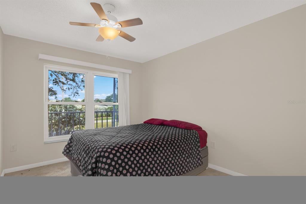 4939 Floramar Terrace, Unit 204 New Port Richey, FL 34652 - Photo 18 of 22 a bedroom with a bed and a large window