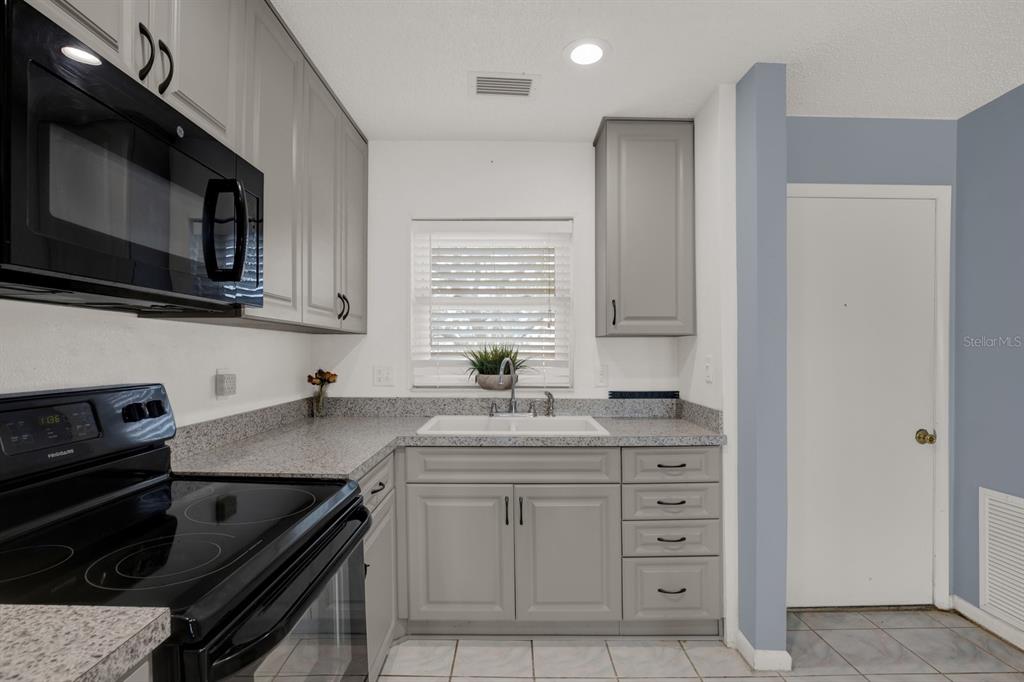 4939 Floramar Terrace, Unit 204 New Port Richey, FL 34652 - Photo 8 of 22 a kitchen with a sink stove and microwave