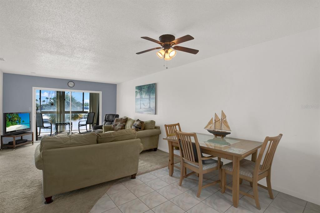 4939 Floramar Terrace, Unit 204 New Port Richey, FL 34652 - Photo 10 of 22 a living room with furniture a chandelier fan and a window
