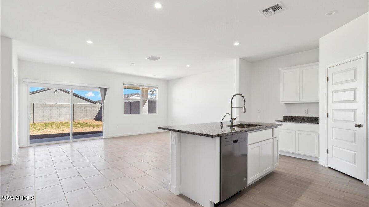 2175 West Spaulding Avenue Apache Junction, AZ 85120 - Photo 5 of 7 a kitchen with stainless steel appliances granite countertop a sink and a stove top oven with white cabinets