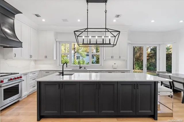 a kitchen with granite countertop a sink a window stainless steel appliances and cabinets