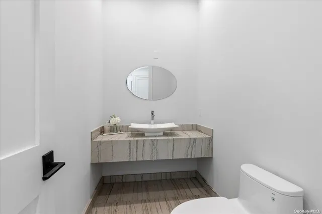a bathroom with a sink a toilet and a mirror