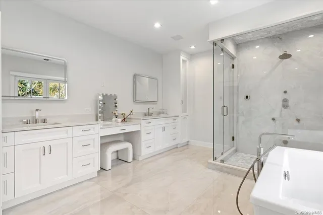 a bathroom with a granite countertop sink mirror and a bathtub