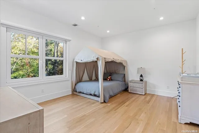 a bedroom with a bed and large windows