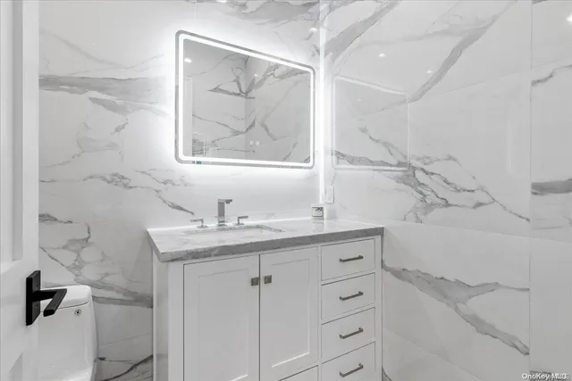 a bathroom with a granite countertop sink a toilet and a bathtub