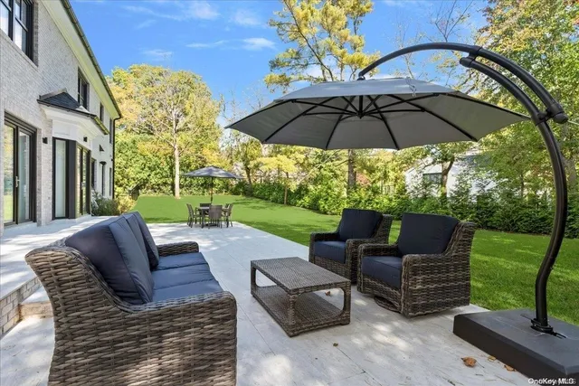a view of a patio with a table chairs and a yard