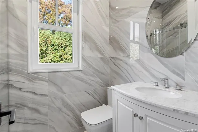 a bathroom with a granite countertop sink toilet and a mirror