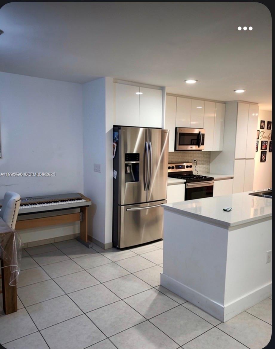 3301 Raleigh Street, Unit 4A Hollywood, FL 33021 - Photo 4 of 11 a kitchen with stainless steel appliances a refrigerator and a stove top oven