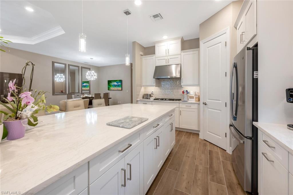 8416 Rosa Court Naples, FL 34114 - Photo 12 of 33 a kitchen with stainless steel appliances a sink a stove a refrigerator a center island and a window