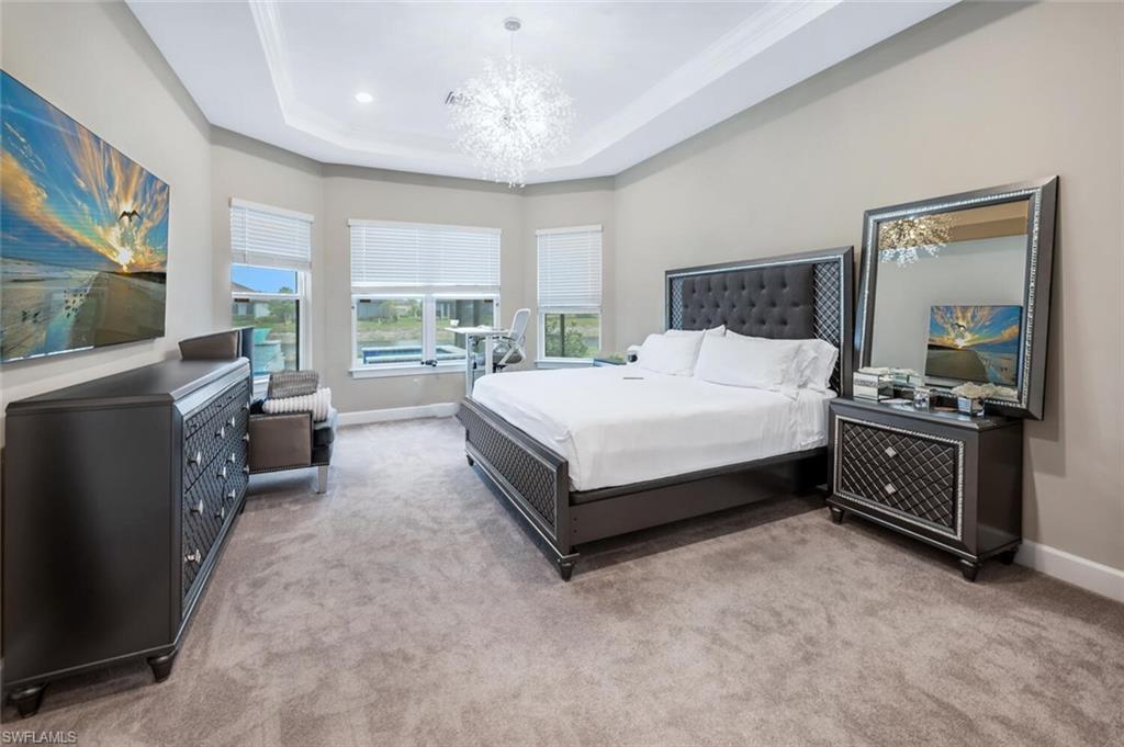 8416 Rosa Court Naples, FL 34114 - Photo 14 of 33 a spacious bedroom with a bed and a flat screen television