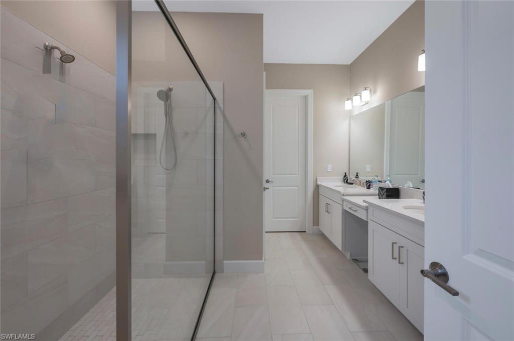 8416 Rosa Court Naples, FL 34114 - Photo 16 of 33 a bathroom with a double vanity sink a mirror and a shower