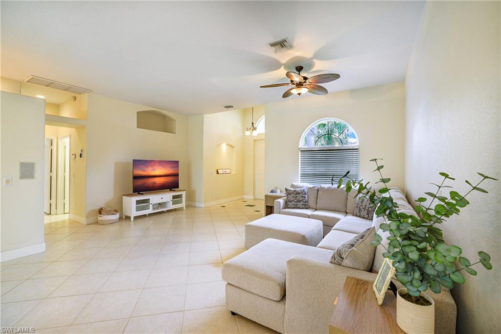 5235 Malvern Court Naples, FL 34112 - Photo 6 of 28 a living room with furniture a fireplace and a flat screen tv