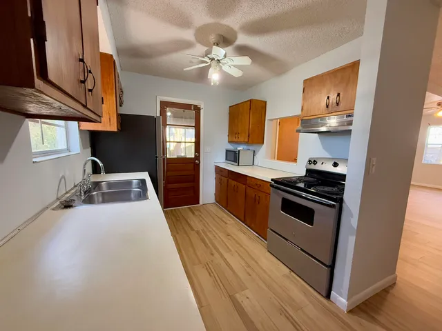 a kitchen with stainless steel appliances a stove a sink and a refrigerator