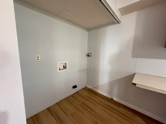 a room with a bed and wooden floor