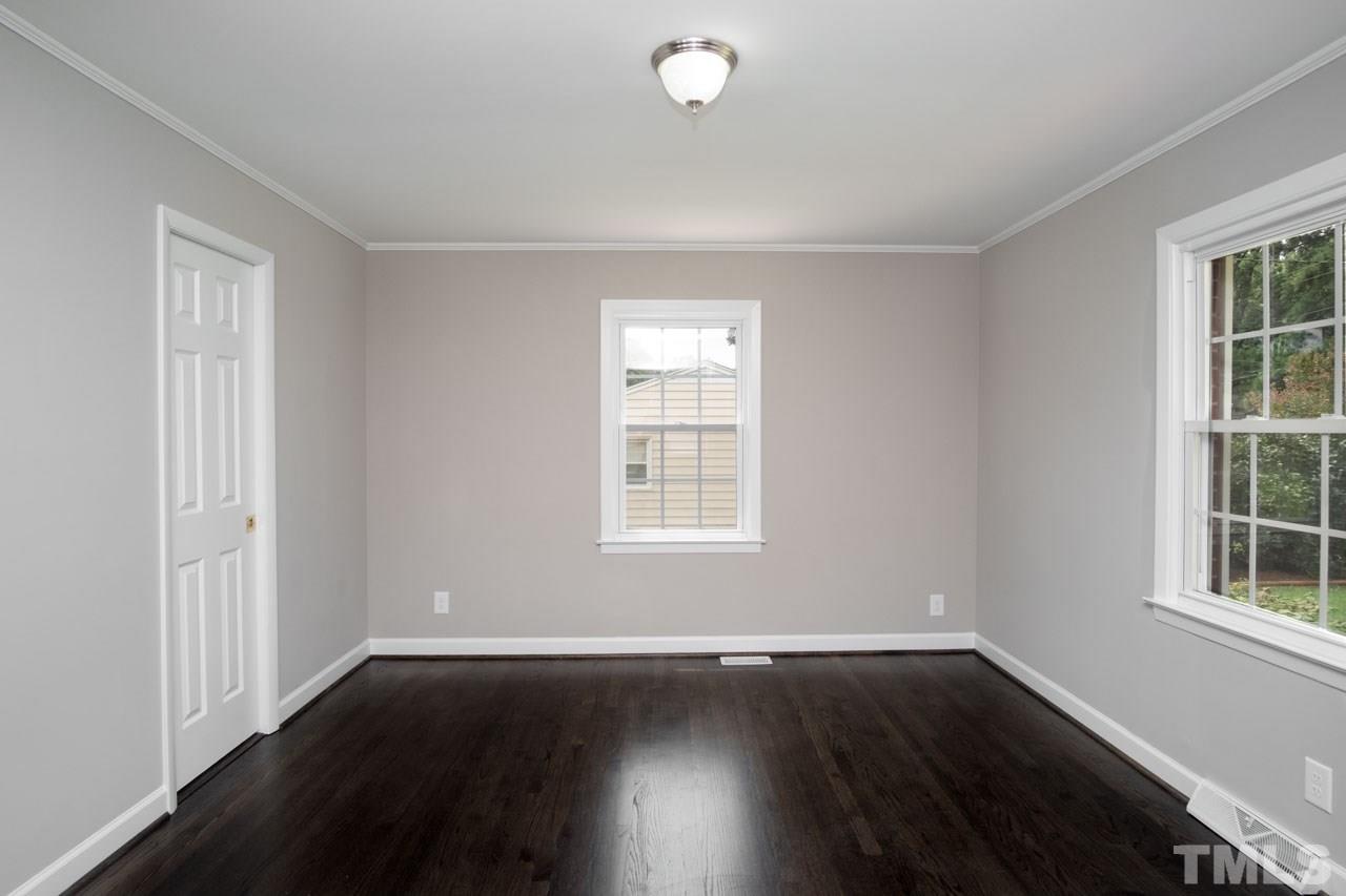 807 Colonial Drive Raleigh, NC 27603 - Photo 14 of 25 a view of an empty room with wooden floor and a window