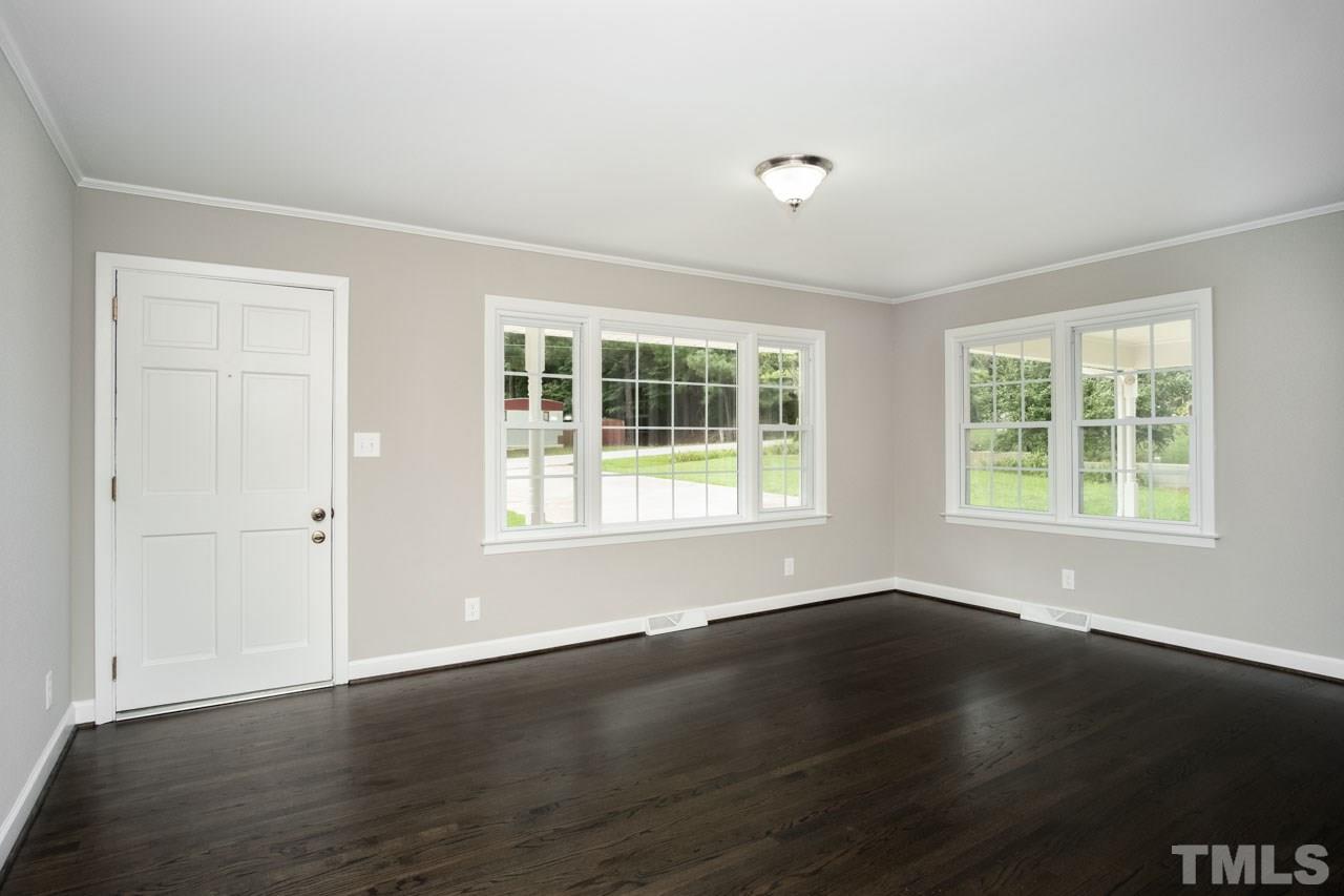 807 Colonial Drive Raleigh, NC 27603 - Photo 8 of 25 a view of an empty room with wooden floor and a window