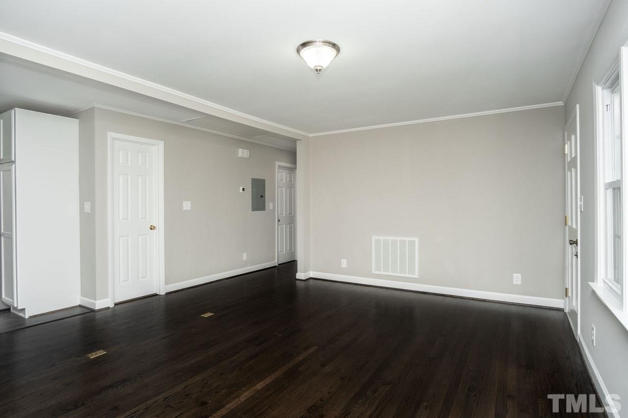 807 Colonial Drive Raleigh, NC 27603 - Photo 9 of 25 an empty room with wooden floor and windows