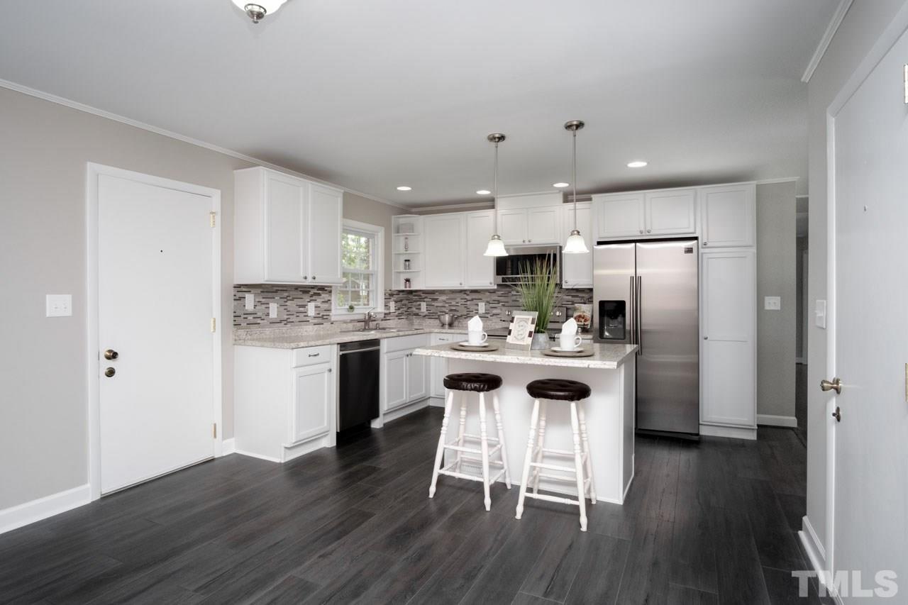 807 Colonial Drive Raleigh, NC 27603 - Photo 10 of 25 a kitchen with kitchen island white cabinets and stainless steel appliances