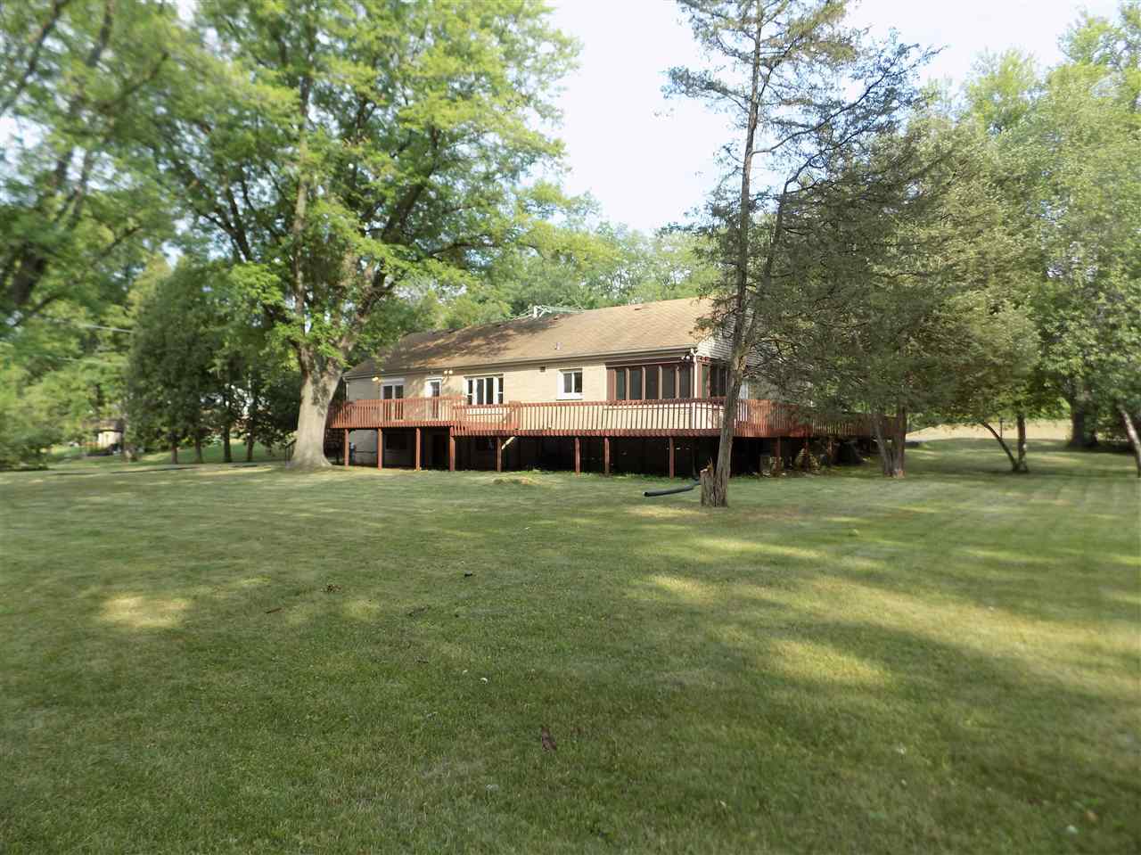4315 Spring Creek Road Rockford, IL 61107 - Photo 34 of 39 a wooden deck with large trees and a big yard