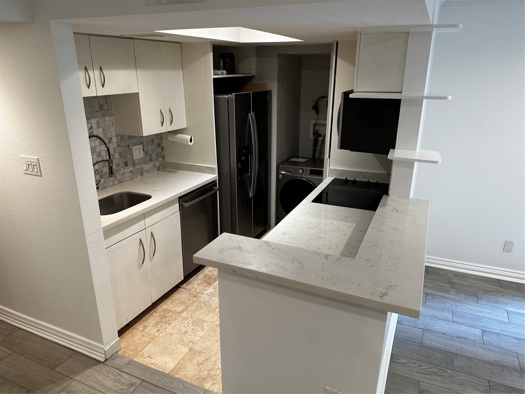 1909 Brun Street, Unit 9 Houston, TX 77019 - Photo 11 of 19 a kitchen with white cabinets and stainless steel appliances