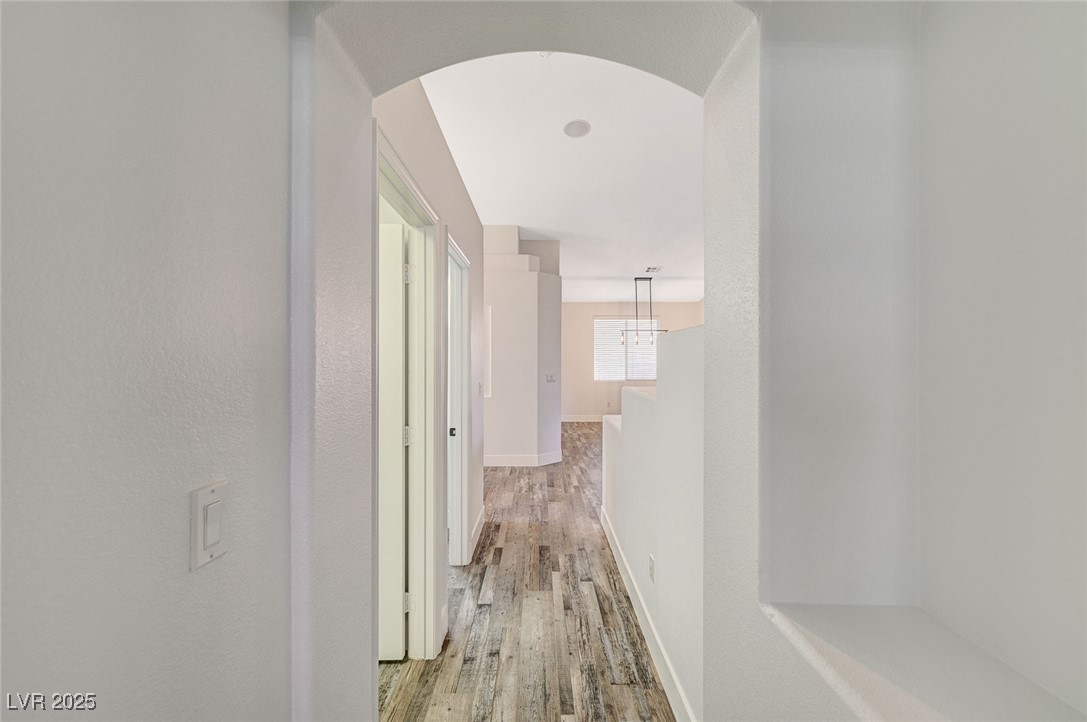 1335 Rolling Sunset Street Henderson, NV 89052 - Photo 13 of 72 Hallway featuring wood finished floors, arched wal