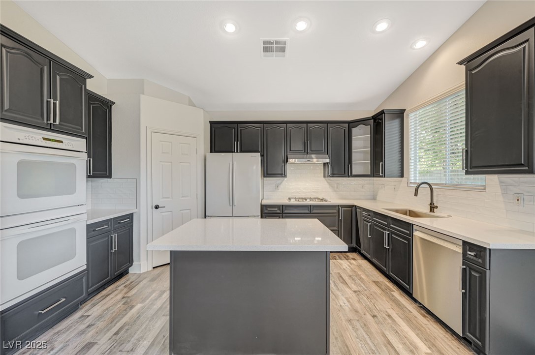 1335 Rolling Sunset Street Henderson, NV 89052 - Photo 30 of 72 Kitchen with visible vents, a kitchen island, a si