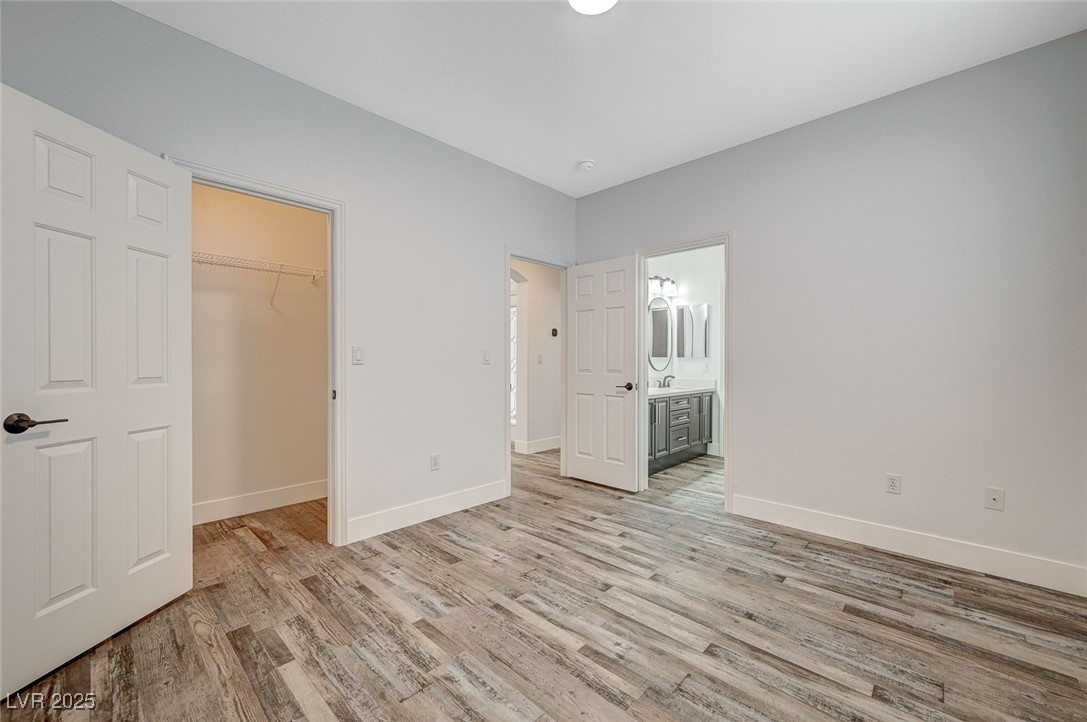 1335 Rolling Sunset Street Henderson, NV 89052 - Photo 36 of 72 Unfurnished bedroom featuring baseboards, a walk i