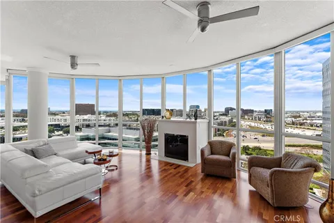 a living room with furniture fireplace and a large window