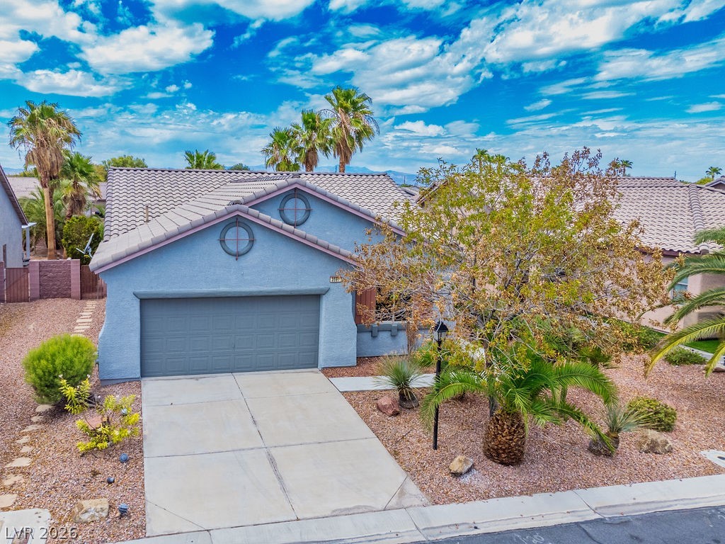 3591 Driving Range Street Las Vegas, NV 89122 - Photo 9 of 79 This residence features a tiled roof and an attached garage with an inviting concrete driveway.