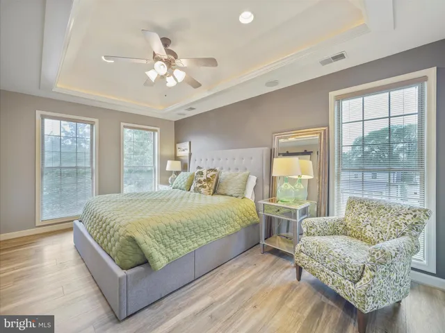 a spacious bedroom with a bed and a chandelier