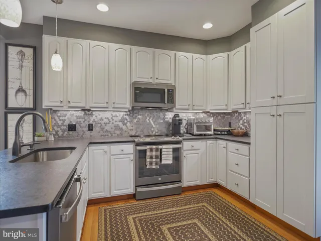 a kitchen with granite countertop a sink stove and cabinets
