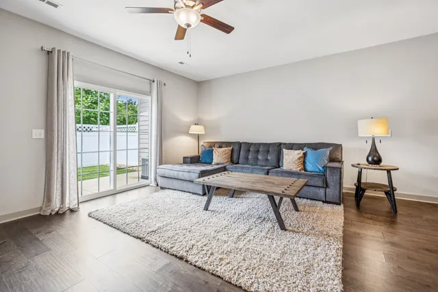 a living room with furniture and a wooden floor