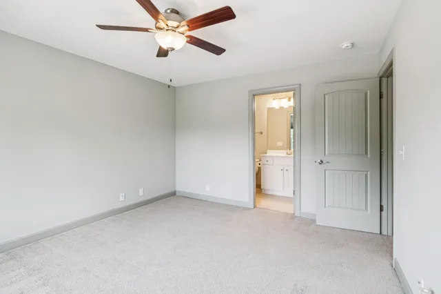 an empty room with a ceiling fan and a window