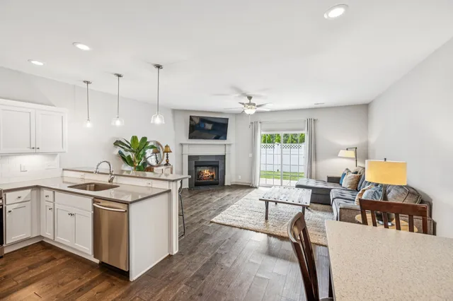 a living room with furniture a fireplace and a open kitchen view