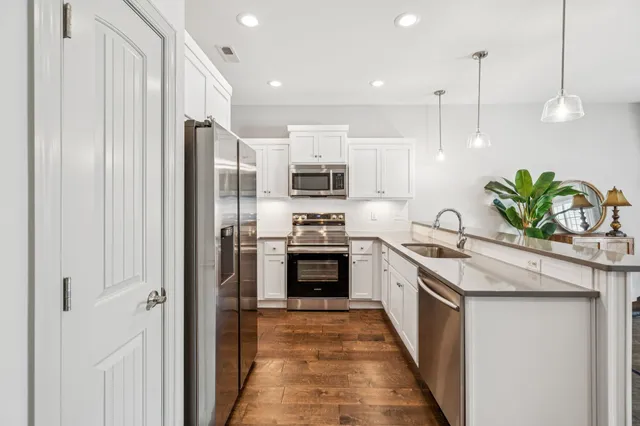 a kitchen with stainless steel appliances a stove a sink and a refrigerator