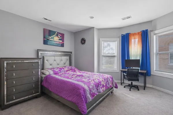 a bedroom with a bed a table and chair