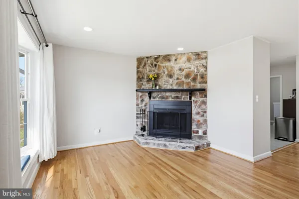 an empty room with windows fire place and refrigerator