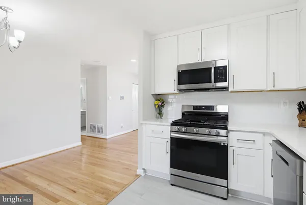 a kitchen with granite countertop a stove and a microwave