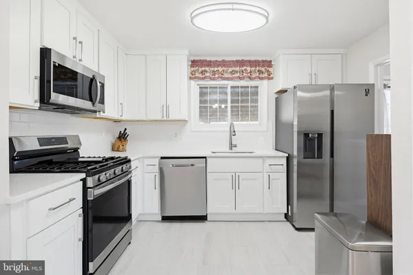 a kitchen with stainless steel appliances a refrigerator stove and microwave